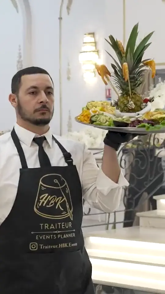 Serveur HBK Traiteur présentant un plateau en salle, service d'un traiteur entreprise à Paris