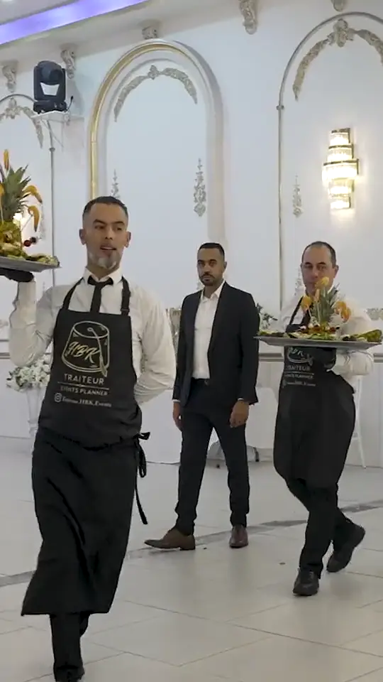 Serveurs HBK Traiteur portant les plateaux dans une salle de mariage, traiteur mariage à Paris